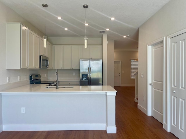 6159 Peaceful Park Way, Clermont, FL 34714 - kitchen with appliances with stainless steel finishes, a sink, a peninsula, light countertops, and pendant lighting