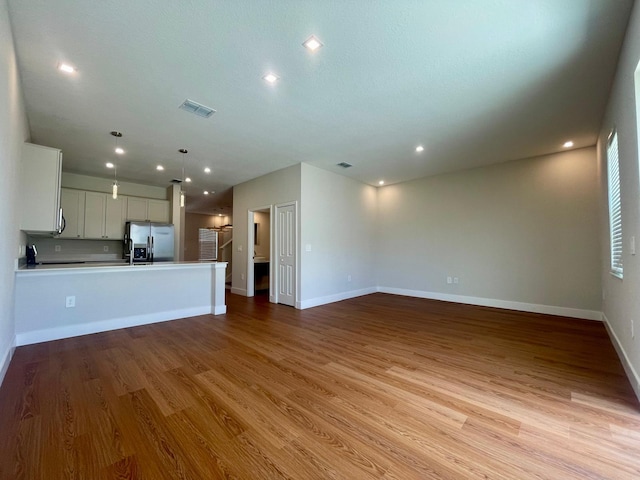 6159 Peaceful Park Way, Clermont, FL 34714 - unfurnished living room featuring wood finished floors, baseboards, and recessed lighting