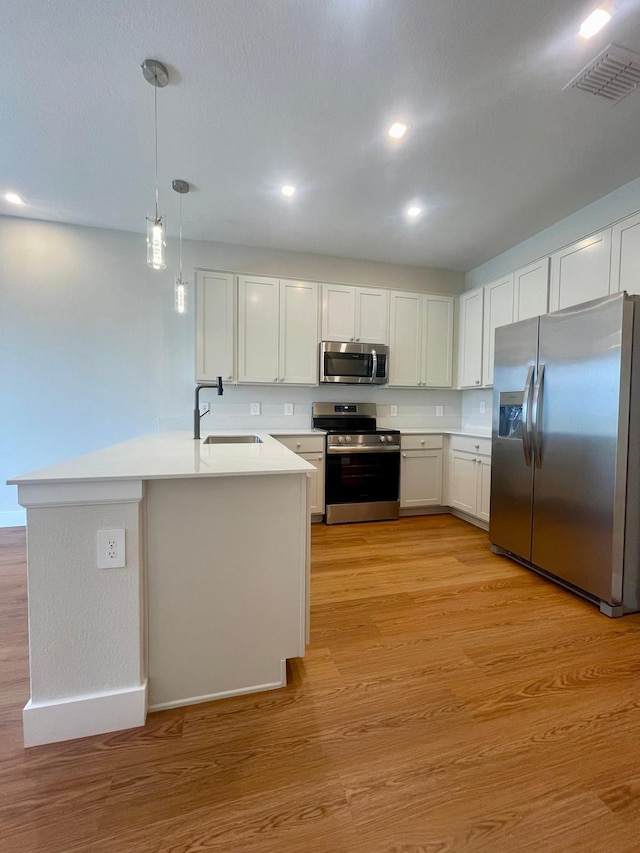 6159 Peaceful Park Way, Clermont, FL 34714 - kitchen featuring appliances with stainless steel finishes, a sink, light wood-type flooring, light countertops, and a peninsula