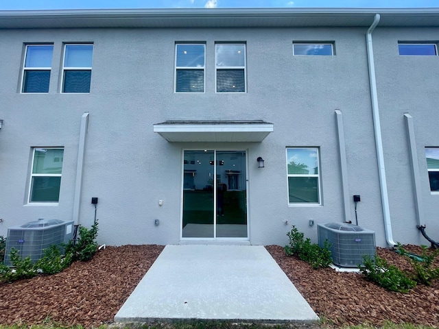 6159 Peaceful Park Way, Clermont, FL 34714 - rear view of property with stucco siding, cooling unit, and a patio