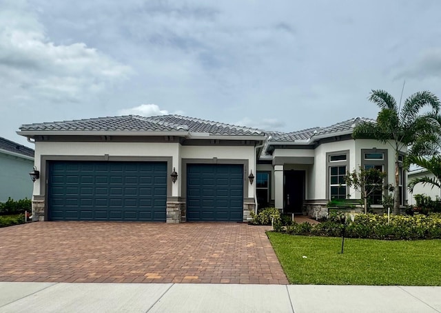 10710 Stellar Cir Unit 03, Palm Beach Gardens, FL 33412 - prairie-style home featuring an attached garage, decorative driveway, stone siding, stucco siding, and a front yard