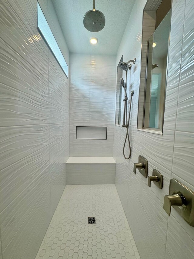 10710 Stellar Cir Unit 03, Palm Beach Gardens, FL 33412 - bathroom with tiled shower, tile walls, a textured ceiling, and tile patterned floors