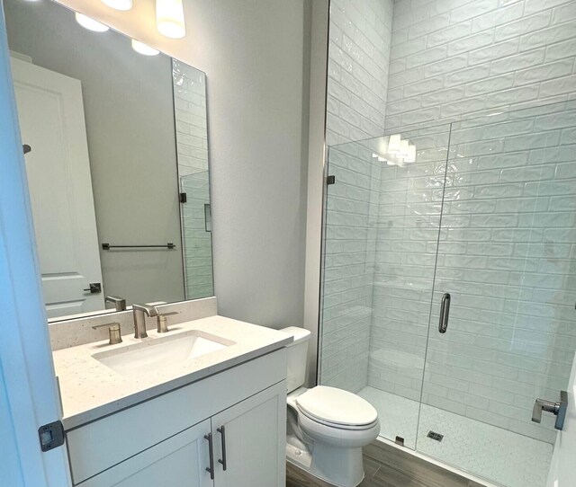 10710 Stellar Cir Unit 03, Palm Beach Gardens, FL 33412 - full bathroom featuring vanity, toilet, a stall shower, and wood finished floors