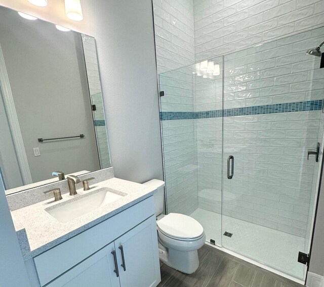 10710 Stellar Cir Unit 03, Palm Beach Gardens, FL 33412 - full bath featuring a shower stall, vanity, wood finished floors, and toilet