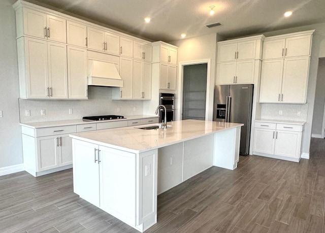 10710 Stellar Cir Unit 03, Palm Beach Gardens, FL 33412 - kitchen featuring appliances with stainless steel finishes, custom exhaust hood, a sink, wood finished floors, and white cabinetry