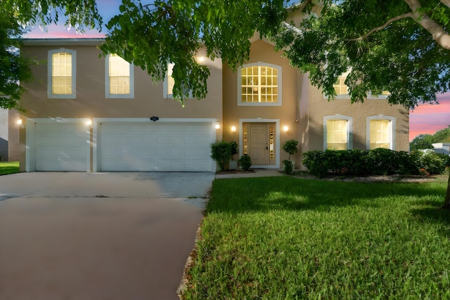 6057 Ridgelake Cir, Vero Beach, FL 32967 - view of front of house featuring a garage, stucco siding, driveway, and a lawn