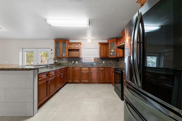 6057 Ridgelake Cir, Vero Beach, FL 32967 - kitchen with refrigerator with ice dispenser, brown cabinets, black electric range, dark stone countertops, and tasteful backsplash