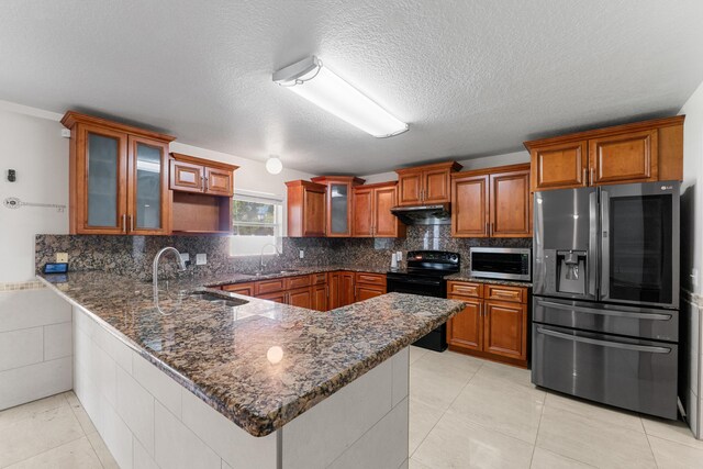 6057 Ridgelake Cir, Vero Beach, FL 32967 - kitchen with appliances with stainless steel finishes, a sink, under cabinet range hood, a peninsula, and brown cabinets