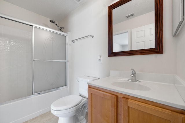 6057 Ridgelake Cir, Vero Beach, FL 32967 - bathroom with toilet, vanity, bath / shower combo with glass door, and tile patterned floors