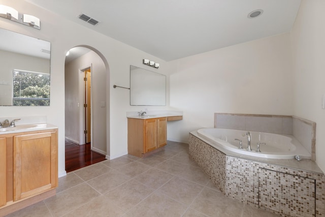 6057 Ridgelake Cir, Vero Beach, FL 32967 - full bath with two vanities, a garden tub, and tile patterned floors