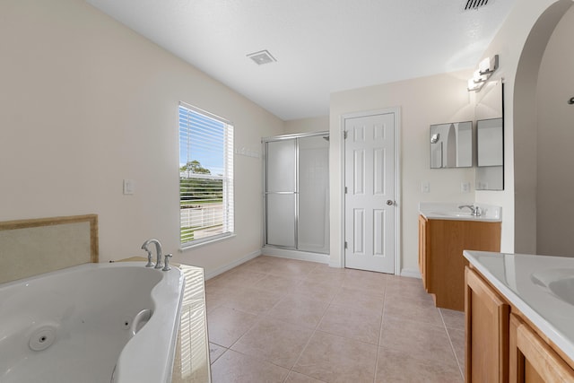 6057 Ridgelake Cir, Vero Beach, FL 32967 - bathroom with two vanities, a shower stall, a whirlpool tub, tile patterned floors, and baseboards