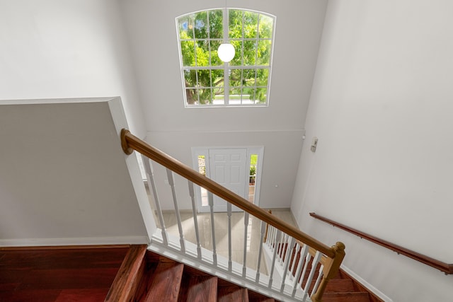 6057 Ridgelake Cir, Vero Beach, FL 32967 - stairs with wood finished floors, baseboards, and a towering ceiling