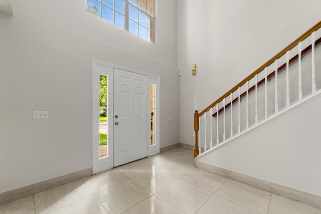 6057 Ridgelake Cir, Vero Beach, FL 32967 - tiled foyer featuring stairs, baseboards, and a high ceiling