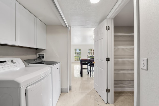 6057 Ridgelake Cir, Vero Beach, FL 32967 - laundry area with cabinet space, washing machine and clothes dryer, light tile patterned floors, a textured ceiling, and baseboards
