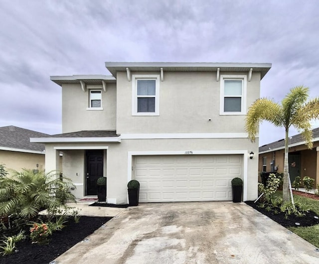 12276 Nettuno Way, Port Saint Lucie, FL 34987 - view of front of house with an attached garage, concrete driveway, and stucco siding