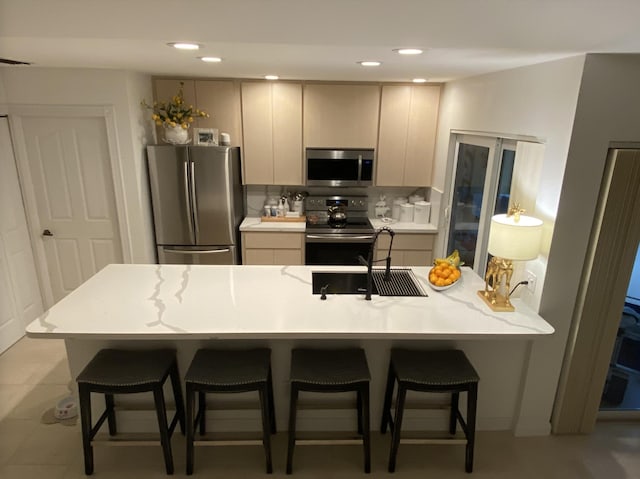 9124 Sun Terrace Cir Unit D, West Palm Beach, FL 33403 - kitchen featuring stainless steel appliances, a breakfast bar area, light countertops, a sink, and recessed lighting