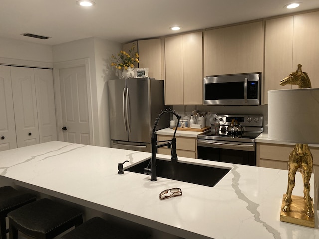 9124 Sun Terrace Cir Unit D, West Palm Beach, FL 33403 - kitchen with stainless steel appliances, a sink, recessed lighting, light stone countertops, and a kitchen bar