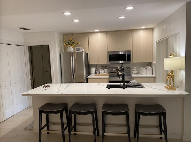 9124 Sun Terrace Cir Unit D, West Palm Beach, FL 33403 - kitchen featuring appliances with stainless steel finishes, a sink, light countertops, a kitchen breakfast bar, and recessed lighting