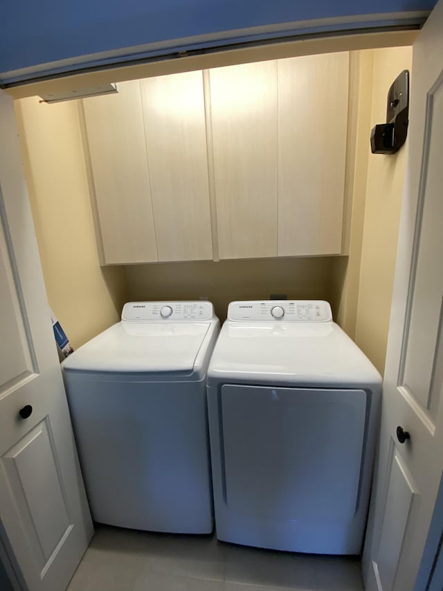 9124 Sun Terrace Cir Unit D, West Palm Beach, FL 33403 - laundry area with cabinet space, washing machine and dryer, and light tile patterned flooring