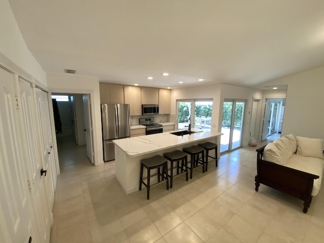 9124 Sun Terrace Cir Unit D, West Palm Beach, FL 33403 - kitchen with appliances with stainless steel finishes, a sink, a breakfast bar, recessed lighting, and an island with sink