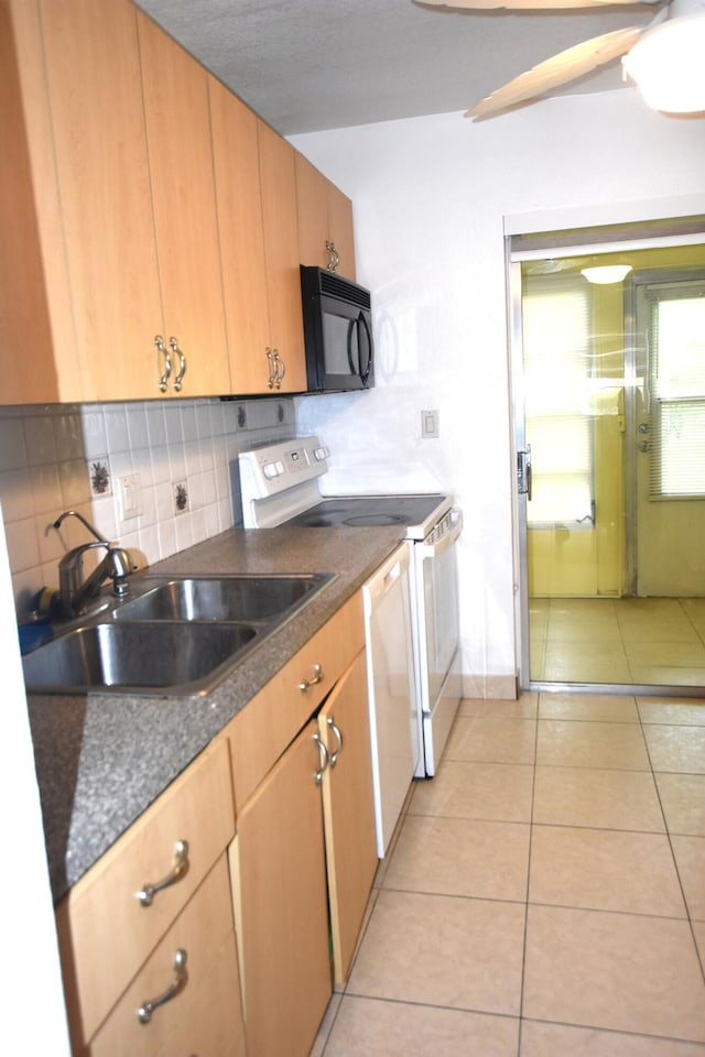 251 NW 76th Ave Unit 105, Margate, FL 33063 - kitchen featuring white appliances, a sink, decorative backsplash, dark countertops, and light tile patterned floors