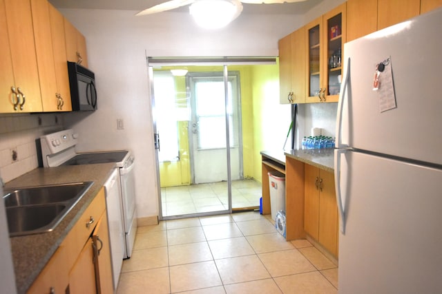 251 NW 76th Ave Unit 105, Margate, FL 33063 - kitchen with white appliances, dark countertops, glass insert cabinets, light tile patterned flooring, and a sink