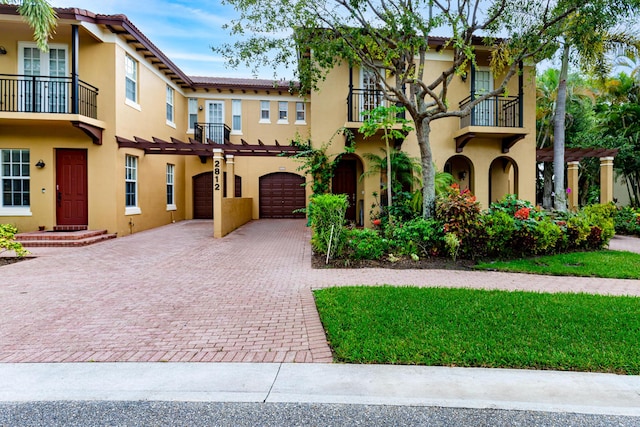 2812 Eagle Rock Cir Unit 902, West Palm Beach, FL 33411 - view of front facade with a balcony, driveway, stucco siding, and a garage