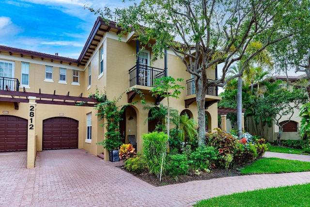 2812 Eagle Rock Cir Unit 902, West Palm Beach, FL 33411 - view of front of home with a balcony, stucco siding, driveway, and an attached garage
