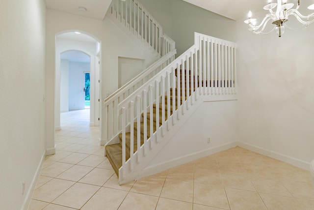 2812 Eagle Rock Cir Unit 902, West Palm Beach, FL 33411 - staircase with tile patterned flooring, a chandelier, and arched walkways
