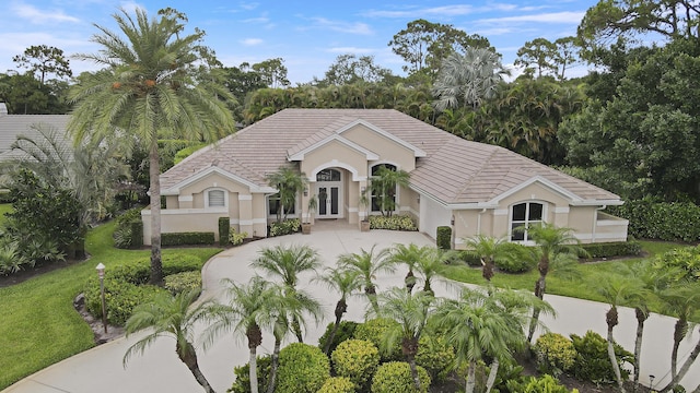 10120 Inverness Way, Port Saint Lucie, FL 34986 - view of front of property featuring concrete driveway, french doors, stucco siding, and a tile roof