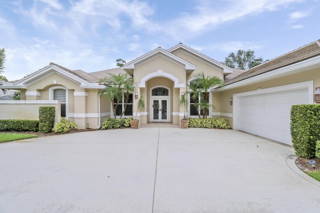 10120 Inverness Way, Port Saint Lucie, FL 34986 - single story home with french doors, stucco siding, concrete driveway, an attached garage, and a tiled roof