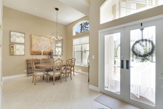 10120 Inverness Way, Port Saint Lucie, FL 34986 - dining space featuring a high ceiling, french doors, a chandelier, light tile patterned floors, and baseboards