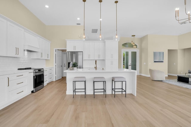 6845 Big Cypress Dr, Jupiter, FL 33458 - kitchen with stainless steel appliances, decorative backsplash, light wood-style flooring, open floor plan, and recessed lighting