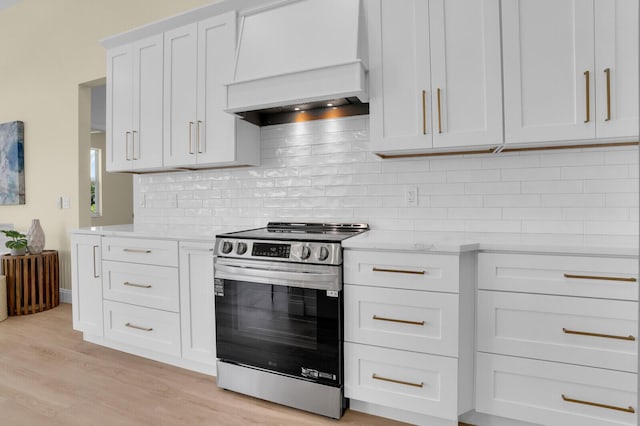 6845 Big Cypress Dr, Jupiter, FL 33458 - kitchen featuring electric stove, premium range hood, light countertops, light wood-style flooring, and tasteful backsplash