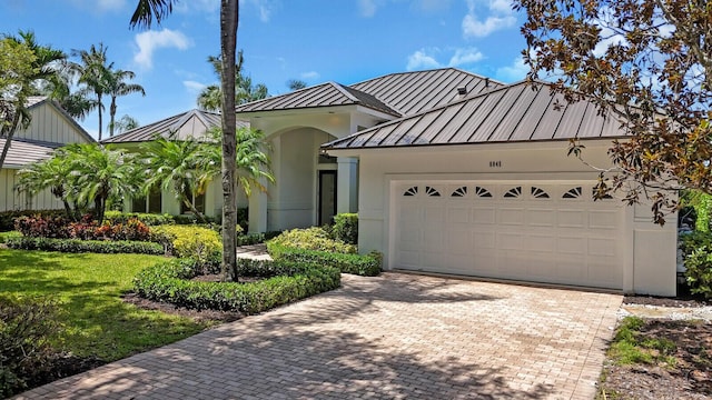 6845 Big Cypress Dr, Jupiter, FL 33458 - view of front facade featuring a standing seam roof, a metal roof, an attached garage, decorative driveway, and stucco siding