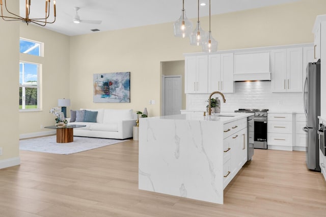 6845 Big Cypress Dr, Jupiter, FL 33458 - kitchen with appliances with stainless steel finishes, a chandelier, tasteful backsplash, white cabinetry, and light stone counters