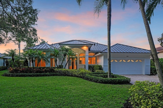 6845 Big Cypress Dr, Jupiter, FL 33458 - view of front of home with a standing seam roof, a metal roof, an attached garage, a lawn, and decorative driveway