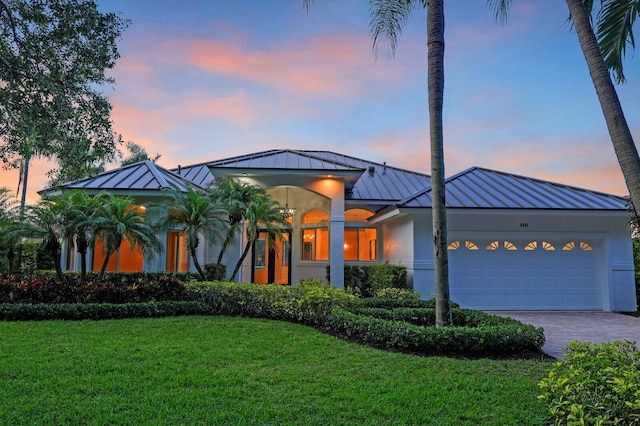 6845 Big Cypress Dr, Jupiter, FL 33458 - view of front of house with a standing seam roof, a metal roof, a lawn, an attached garage, and driveway