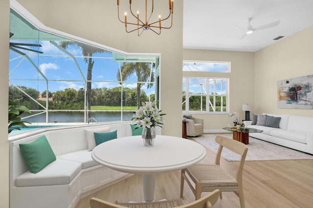 6845 Big Cypress Dr, Jupiter, FL 33458 - dining space with a ceiling fan, light wood-style flooring, a water view, and a chandelier