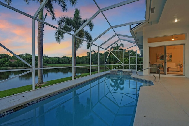 6845 Big Cypress Dr, Jupiter, FL 33458 - pool at dusk featuring an outdoor pool, a water view, glass enclosure, and a patio