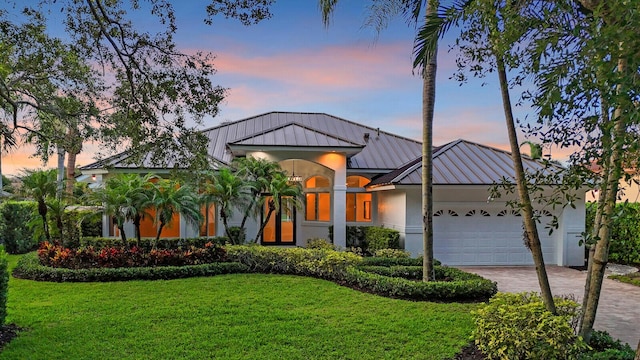 6845 Big Cypress Dr, Jupiter, FL 33458 - view of front facade featuring a standing seam roof, stucco siding, decorative driveway, a garage, and a metal roof