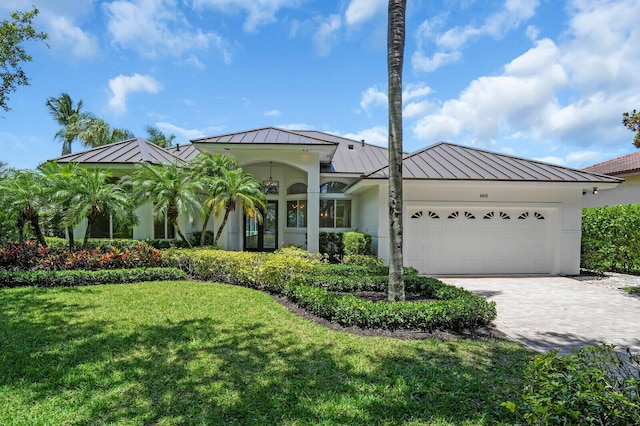 6845 Big Cypress Dr, Jupiter, FL 33458 - view of front of property featuring a standing seam roof, a metal roof, a garage, and a front lawn