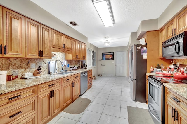 7574 Ironbridge Cir, Delray Beach, FL 33446 - kitchen featuring appliances with stainless steel finishes, a sink, tasteful backsplash, light tile patterned flooring, and a textured ceiling