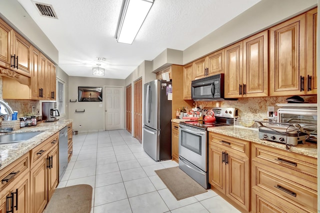 7574 Ironbridge Cir, Delray Beach, FL 33446 - kitchen featuring stainless steel appliances, a sink, light tile patterned floors, tasteful backsplash, and a textured ceiling