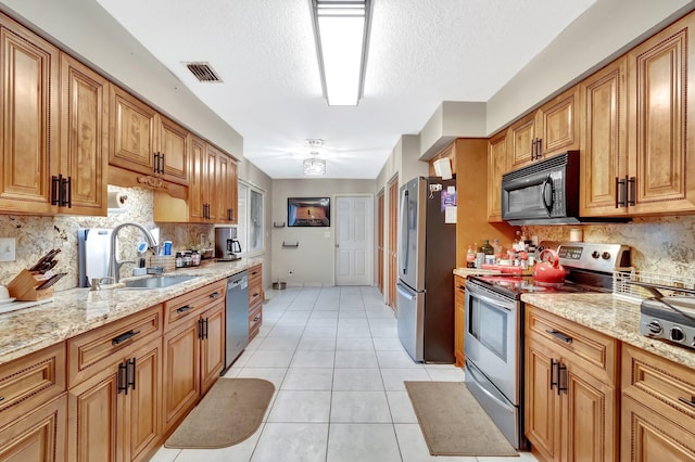 7574 Ironbridge Cir, Delray Beach, FL 33446 - kitchen with stainless steel appliances, tasteful backsplash, a sink, light stone countertops, and a textured ceiling