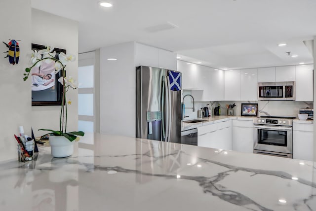 1841 Bridgewood Dr, Boca Raton, FL 33434 - kitchen featuring appliances with stainless steel finishes, modern cabinets, a sink, white cabinets, and decorative backsplash