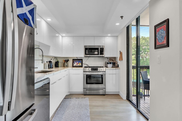 1841 Bridgewood Dr, Boca Raton, FL 33434 - kitchen with stainless steel appliances, a sink, modern cabinets, white cabinetry, and light countertops