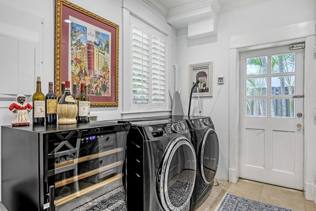 134 Worth Ct N, West Palm Beach, FL 33405 - laundry room with washing machine and clothes dryer, light tile patterned flooring, crown molding, and a bar