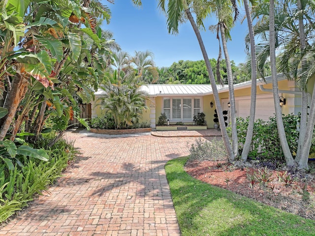 134 Worth Ct N, West Palm Beach, FL 33405 - view of front of property featuring stucco siding, decorative driveway, and a garage