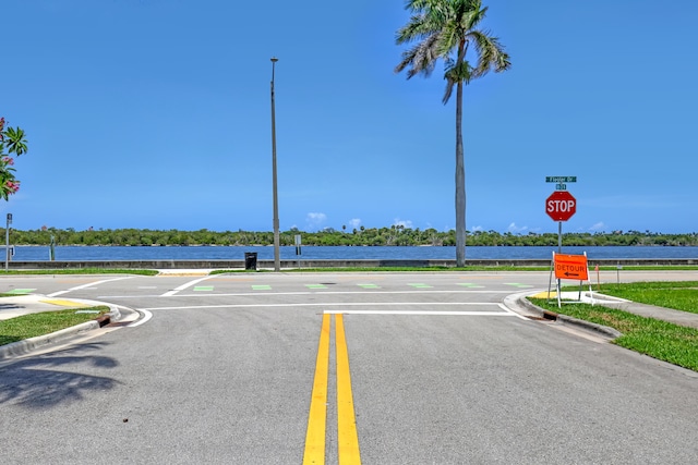 134 Worth Ct N, West Palm Beach, FL 33405 - view of asphalt road with curbs, traffic signs, street lighting, and sidewalks